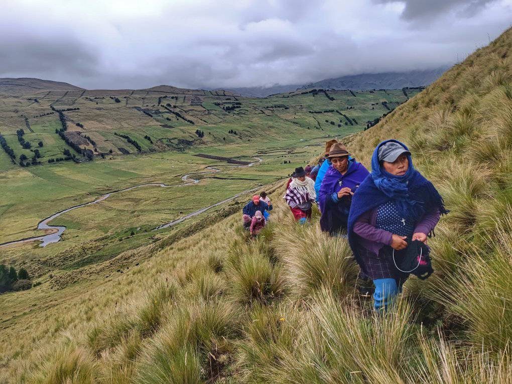 Donne con scialli colorati camminano lungo il crinale di una valle andina