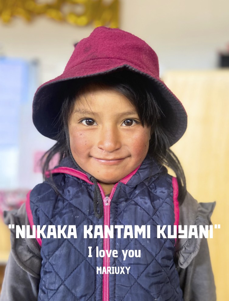 Bambina ecuadoriana con cappello bordeaux e la scritta 'Nukaka kantami kuyani - I love you', foto della mostra itinerante